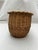 A single vintage oval wicker basket with rounded sides.