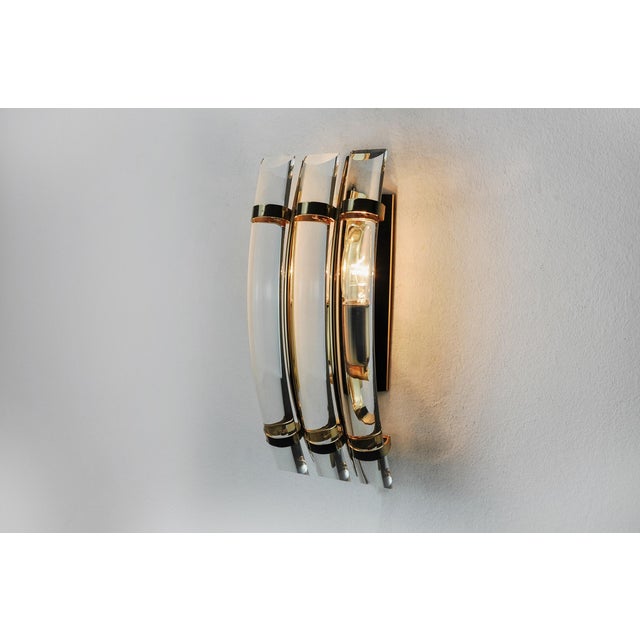 Very beautiful venini wall lamp produced in italy in the 70s. Curved half-moon crystals supported by a gilded metal...