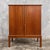 a compact teak drinks cabinet with sculpted wooden handles and a raised four-leg frame. Details danish attribution, circa...