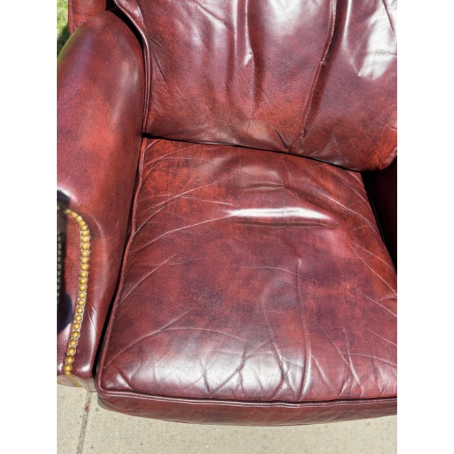 This is a burgundy, leather wingback chair by Hancock and moore. This beautiful burgundy chair has a straight tapered leg...