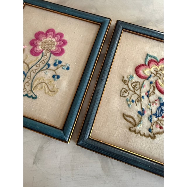 A charming pair of vintage crewel embroidery panels, beautifully framed in soft blue wood frames with subtle gold trim....