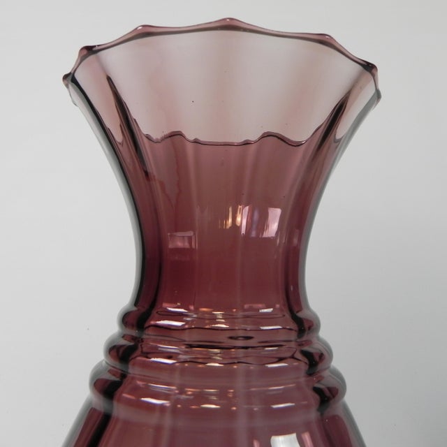 Model from the Art Deco period made of purple glass with horizontal ribs, vertical stripes and a corrugated collar. The...