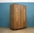 1950s limed oak wardrobe with carved vertical panels and metal handles, raised on shaped feet with a curved base. Central...