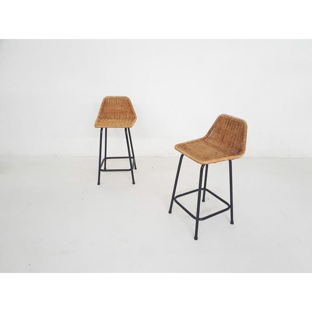 About this item Black metal bar stools with rattan seating. The frame has been repainted, the rattan is in good condition...