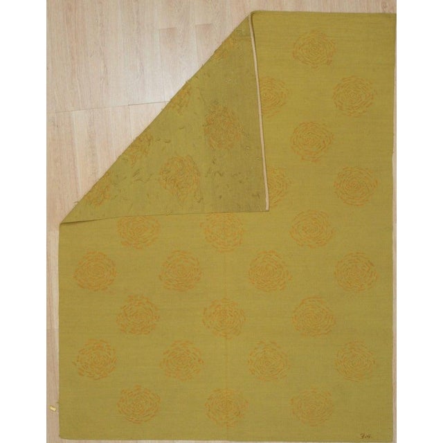 This yellow, gold, and orange rug is a flat weave Kilim constructed entirely from wool. It features a medium pile...