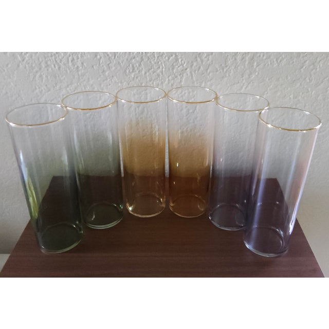 These rare vintage mid-century modern iridescent highball tumblers with gold rims are stunning. The set features a...