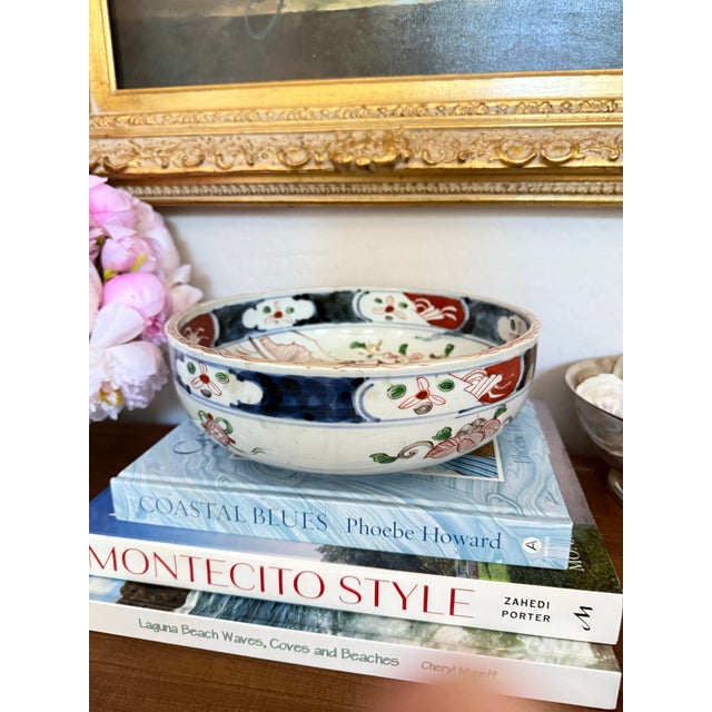 Striking vintage Japanese-style porcelain bowl featuring hand-painted floral, landscape, and geometric motifs in a classic...