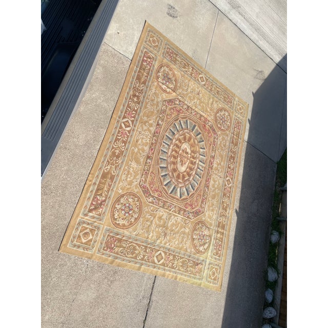 A flatweave Aubusson-style wool rug, likely a contemporary reproduction of 18th-century French neoclassical designs....