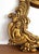 A mid century carved wood mirror in gilt finish. Ornate Rococo style with two native Islander figures. There is one crack...
