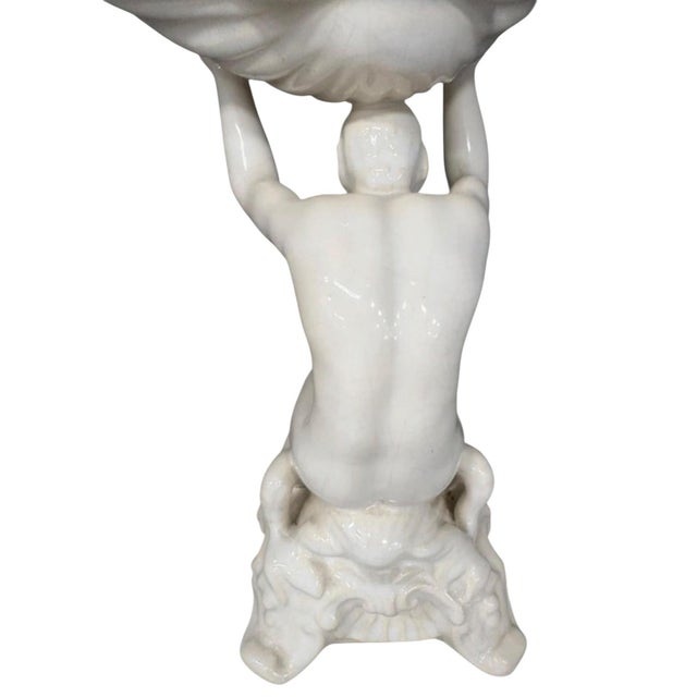 Sculptural vintage Portuguese ceramic centerpiece featuring a kneeling male figure supporting an oversized shell-form...