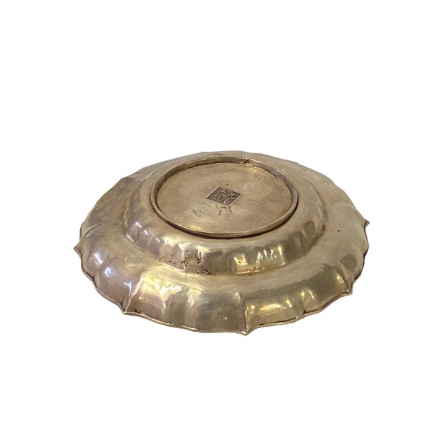 This unique silver-colored oriental-style plate charger is made of metal and has detailed hand carving on the body. The...