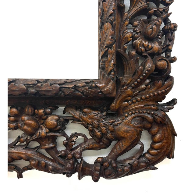 An ornately carved antique wooden frame from the 18th Century. The frame is heavily embellished with detailed wood...