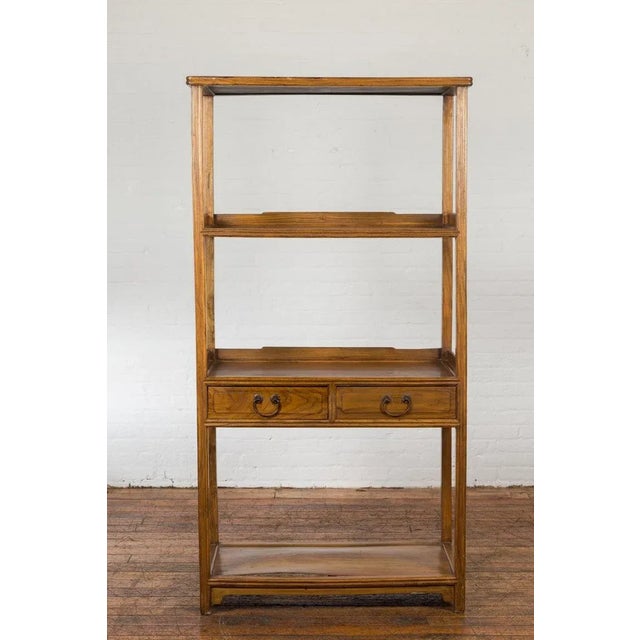 A Chinese late Qing Dynasty period bookcase from the early 20th century with classic design, four shelves and two drawers....