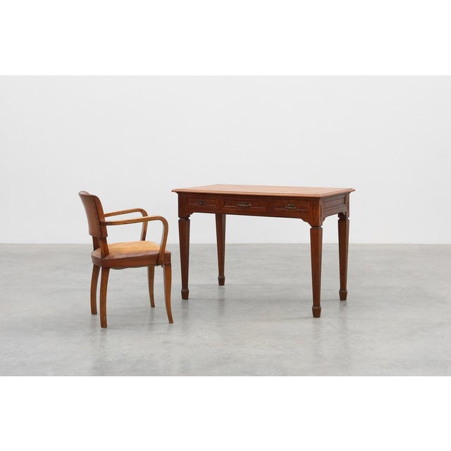An elegant Belgian Art Deco desk from the 1920s, crafted in oak and accented with refined copper hardware. The design...