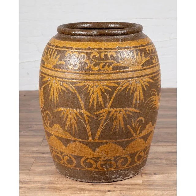 A large Chinese antique jar from the turn of the century, with mustard glaze and floral and bird motifs. Born in China in...