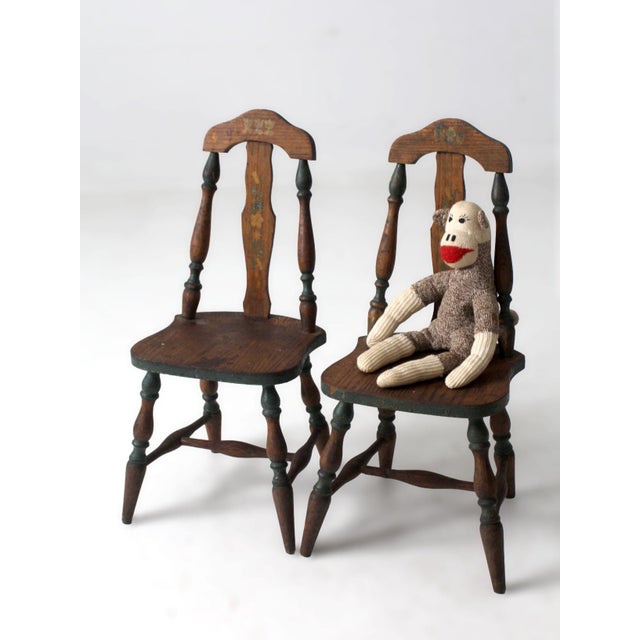 A charming pair of vintage children’s chairs featuring hand-painted floral details and softly turned legs. The shaped...