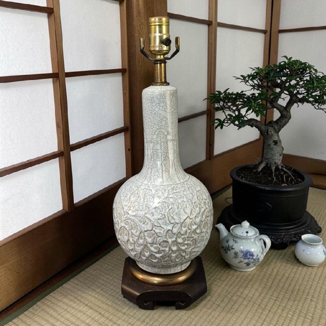 This Asian Pale Celadon Green Color Crackled Ceramic Embossed Design Table Lamp is a vintage piece that exudes an Asian...