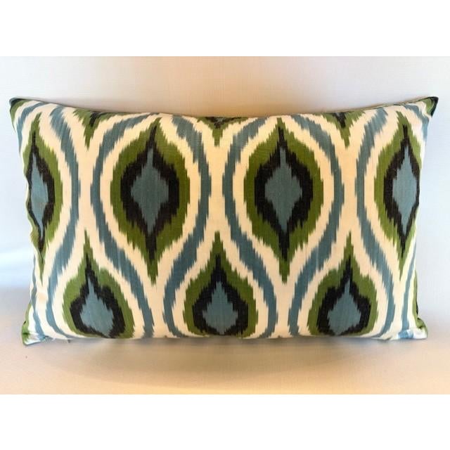 A stunning pillow from Les Ottomans embroidered with a blue, green and yellow floral pattern on a delicate silk fabric....
