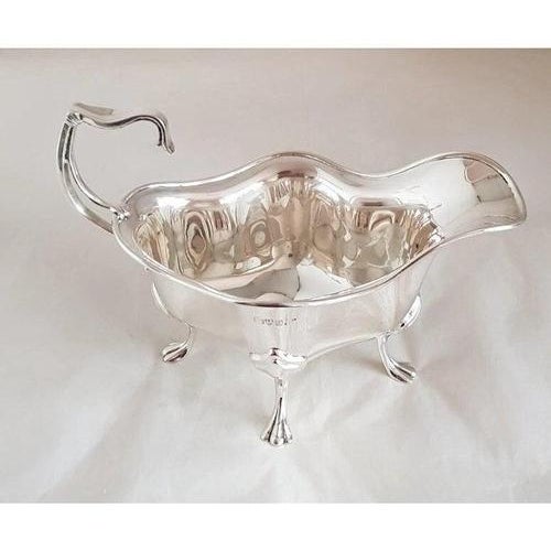 A fine Edwardian sterling silver sauce or gravy boat by the renowned British silversmiths Walker & Hall, hallmarked in...