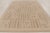 This handwoven wool 9x12 Art Deco rug features a geometric pattern of vertical bands and pixel-like motifs in soft ivory...