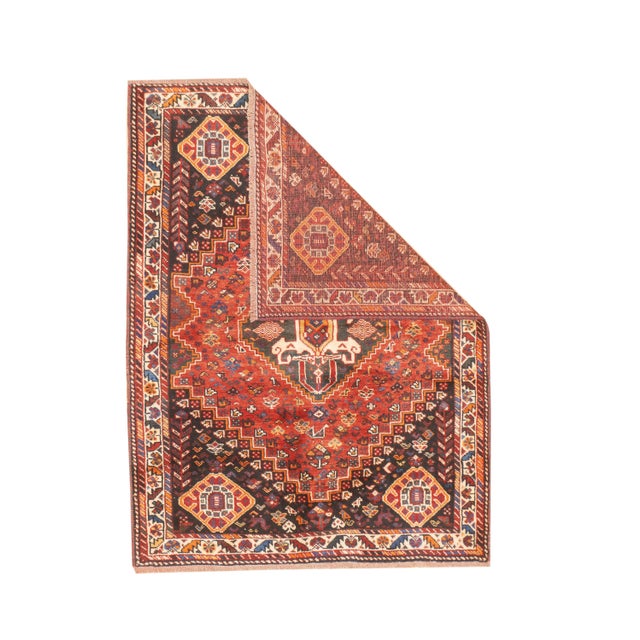Vintage Persian Qashqai hand-knotted rug featuring a bold geometric medallion design set within a richly patterned field....