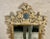 An early 20th century carved and gilt wood wall mirror with an ornately carved crest and “S. Cavallo Inc.” marking on...