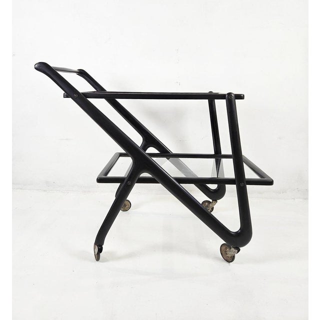 An original two tiered midcentury bar cart by Cesare Lacca, Italy. Made in stained lacquered beech in a design typical for...