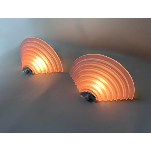 A striking pair of vintage wall sconces dating from the 1980s, featuring spectacular fan-shaped diffusers made of thick,...