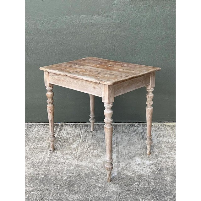Primitive character meets practical proportion in this vintage wooden table, crafted from pine with elegantly turned legs...