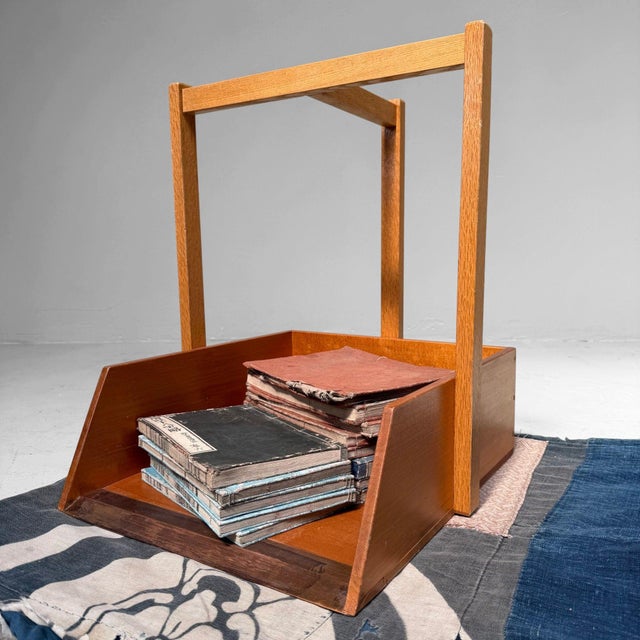A distinctive Japanese wooden dustpan, made as an elegant portable object with a tall handle and a copper front edge....