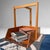 A distinctive Japanese wooden dustpan, made as an elegant portable object with a tall handle and a copper front edge....