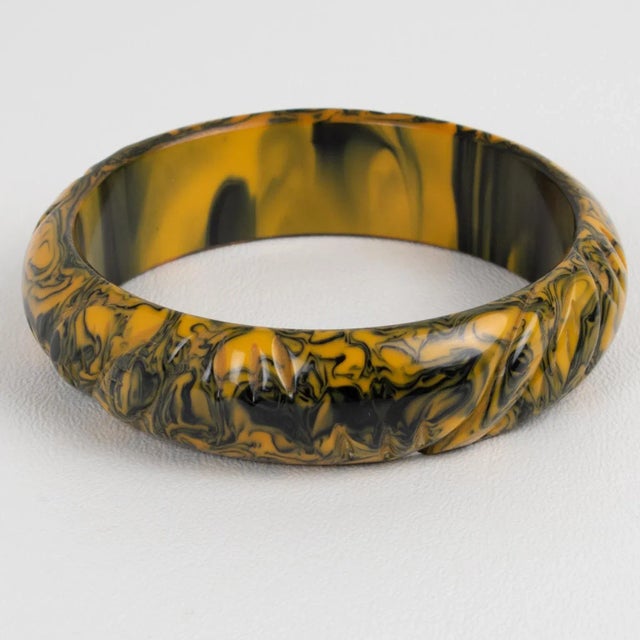 This is a lovely black and yellow butterscotch marble Bakelite carved bracelet bangle. It features a chunky domed shape...