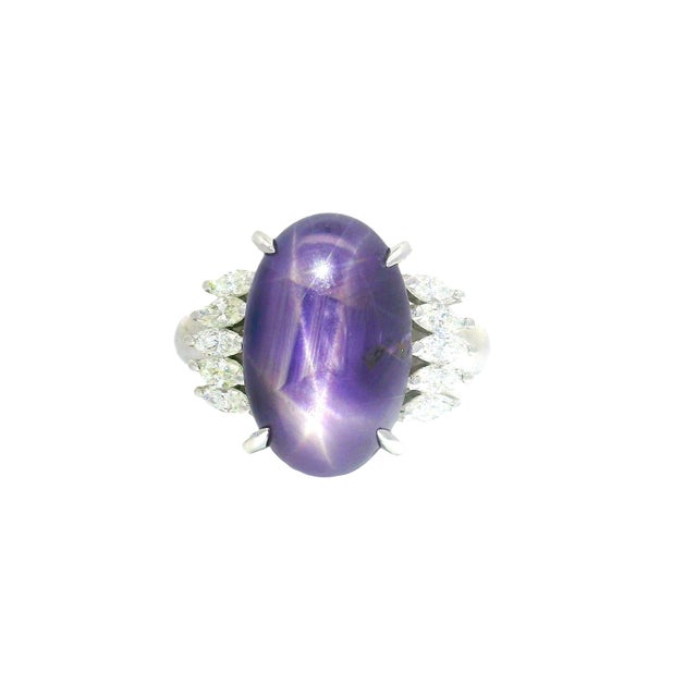 A striking cocktail ring crafted in platinum. The centerpiece is a captivating purple star sapphire, weighing 12.13...