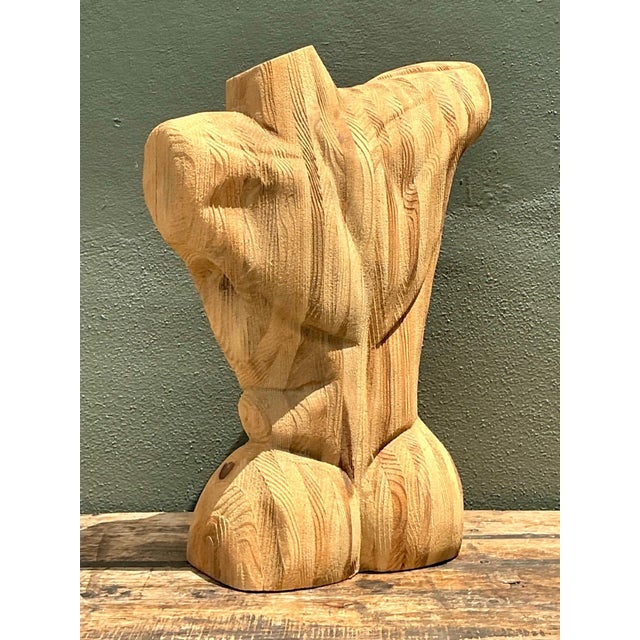 This abstract wood torso captures the human form through bold, sweeping curves rather than literal anatomy. Hand-carved...