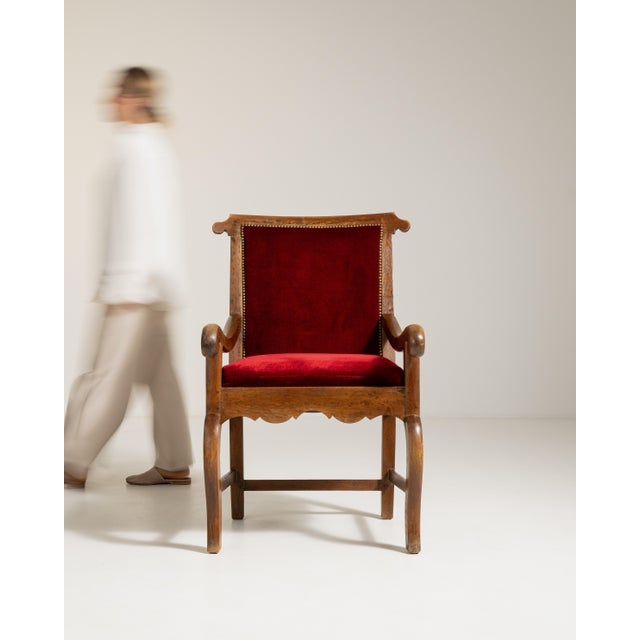 A classic Voltaire armchair characterized by its high back and reclining comfort, originally designed in 19th century...