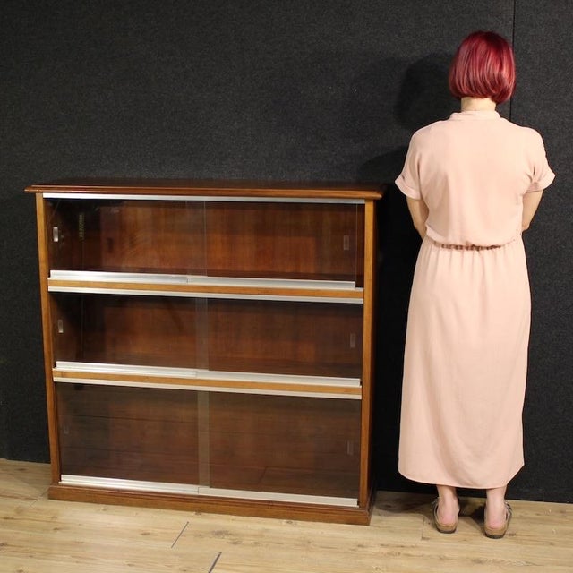 Italian design display cabinet from the 1960s/70s. Walnut bookcase with glass doors that slide on metal tracks. Excellent...