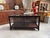 This vintage glass-fronted display case has been fully restored. It features a black-patinated cabinet body; its three...