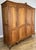 An elegant Vintage French Louis wardrobe in oak, featuring four panelled doors, a gently shaped top, decorative central...