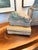 An exceptional sculptural lion resting atop a stack of decorative books, rendered in heavy cast metal and finished with a...