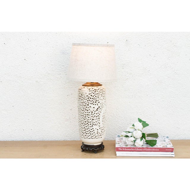 This sophisticated table lamp is crafted from an antique-inspired white porcelain vessel featuring a remarkable see-...