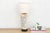 This sophisticated table lamp is crafted from an antique-inspired white porcelain vessel featuring a remarkable see-...