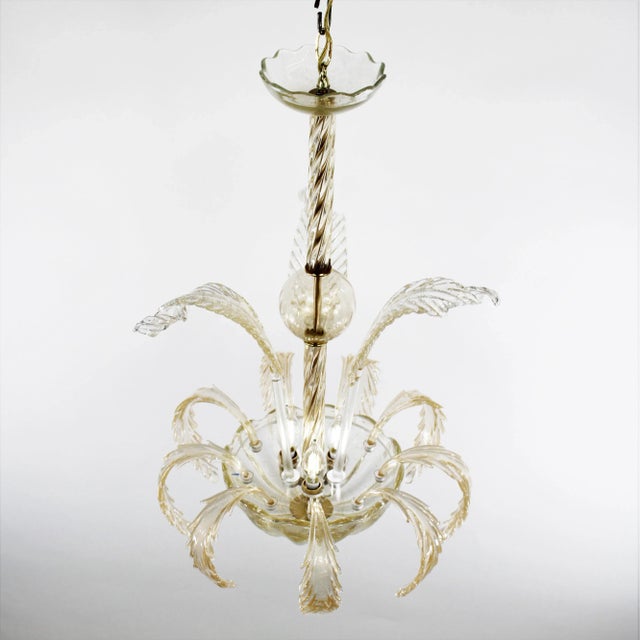 This beautifully handcrafted mid-century cristallo Murano ceiling lamp is adorned with beautiful golden leaves. The...