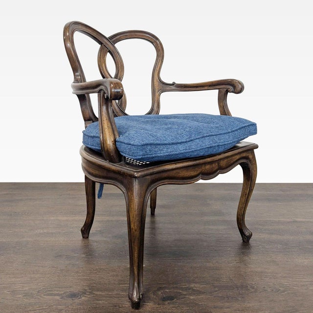 This classic dining chair features a solid wood frame with a curved back, cabriole legs, and carved armrests. The seat is...