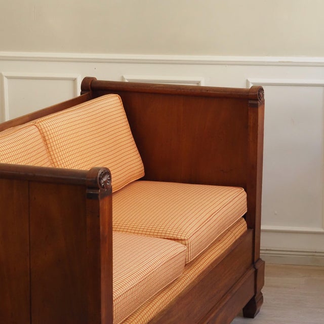 A two-piece upholstered sofa in mahogany, created around the mid-19th century within the Biedermeier style, with rolled...