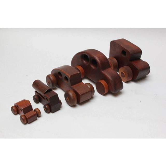 Set of five wooden, handmade toy cars / trucks (ca. 1970s, USA). The three smaller examples are pine and maple made by...