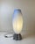 Astonishing table lamp with an industrial fluted aluminum base under an elongated, oval-shaped shade of blown, frosted...