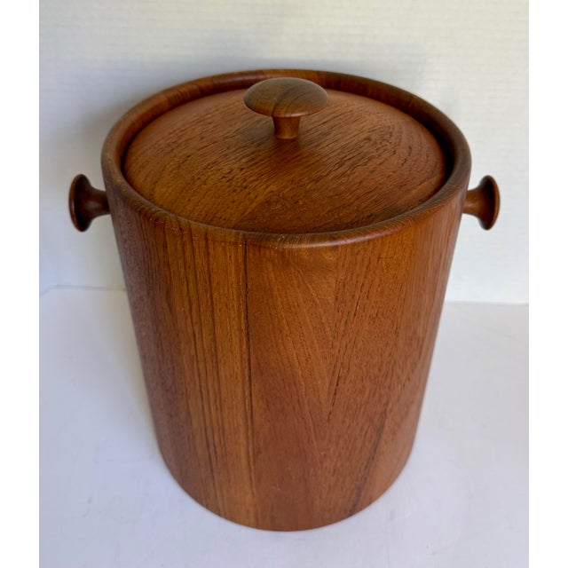 This vintage mid-century modern ice bucket, dating to the 1960s–70s, features a clean cylindrical form wrapped in warm...