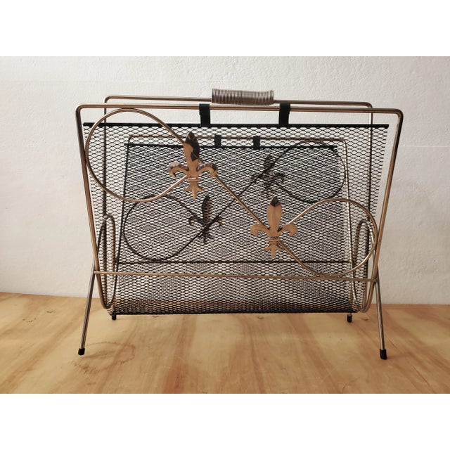 Mid Century Era Magazine Rack. c. 1960's. Tubular gold tone steel frame with contrasting black matte interior nest with...