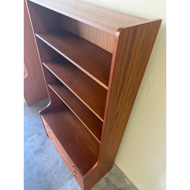 This elegant vintage Danish teak bookcase combines open display shelving with concealed drawer storage, making it both...