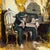 Something in the Way by Nadezda | Oil on panel of a man slumped in a chair with a gramophone nearby For Sale